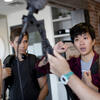 High school students work together on setting up a microphone.