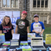 Three students standing in front of table at fair